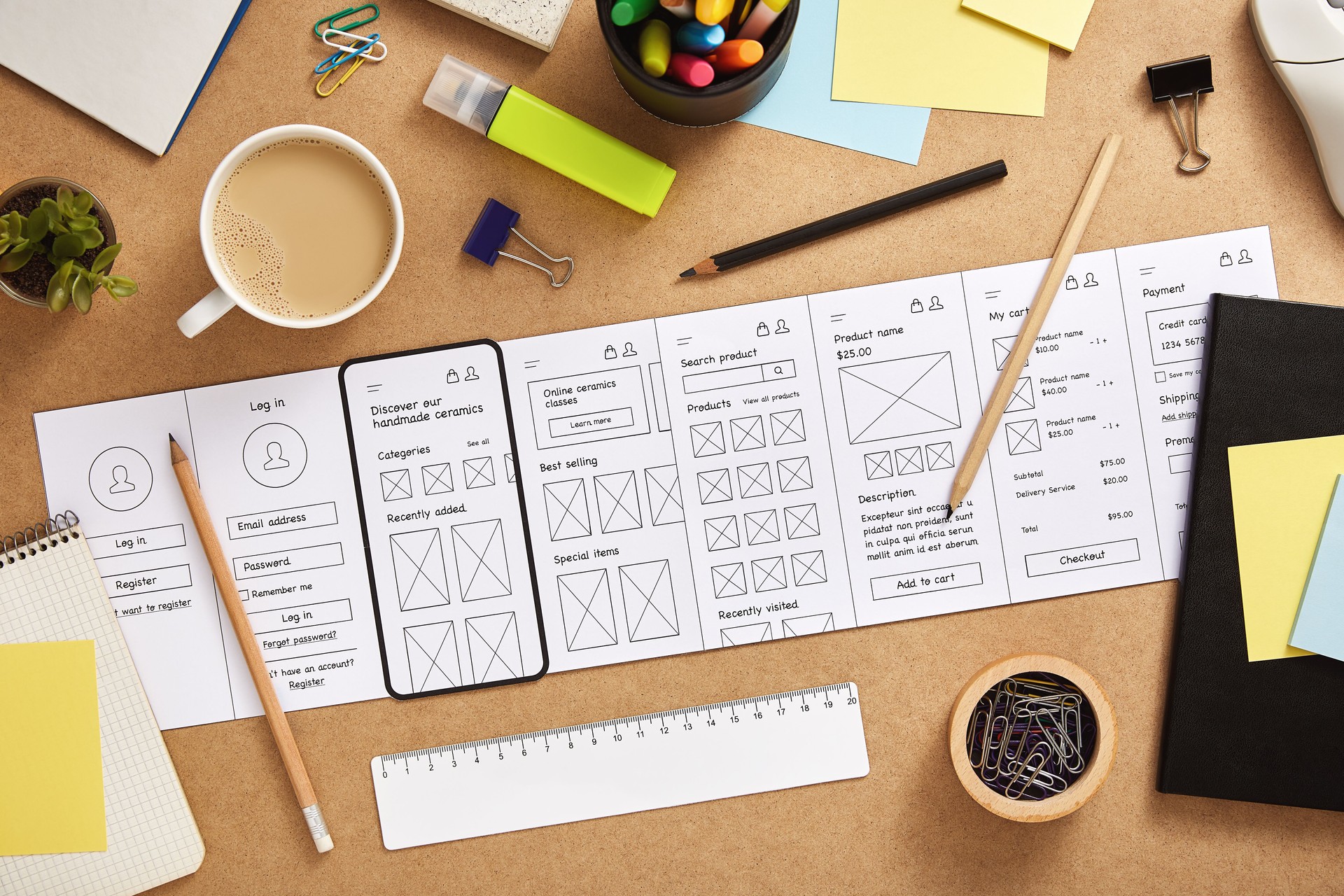 Mobile app wireframes over UX designer desk